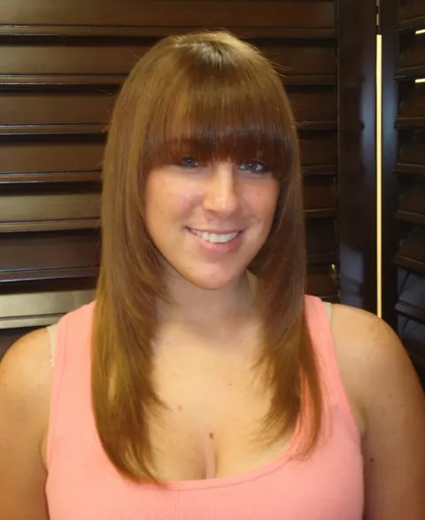 Long layered haircut with fringe by Razoux & Co