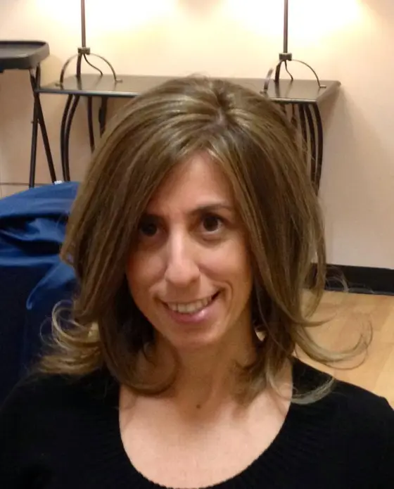 Smiling client with a layered brunette cut