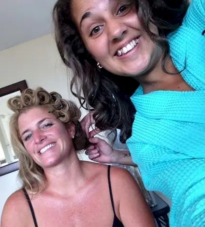 Two smiling women getting their hair styled
